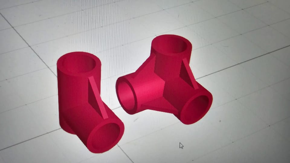 Two red 3D-printed pipe connectors